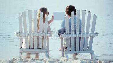 一对年轻夫妇坐在躺椅上拿着便签
